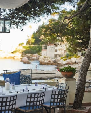 Restaurant terrace with a linen-coated table and elegant wrought-iron chairs